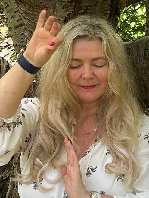 The Galactic High Priestess in a meditation blessing pose under a tree, eyes closed